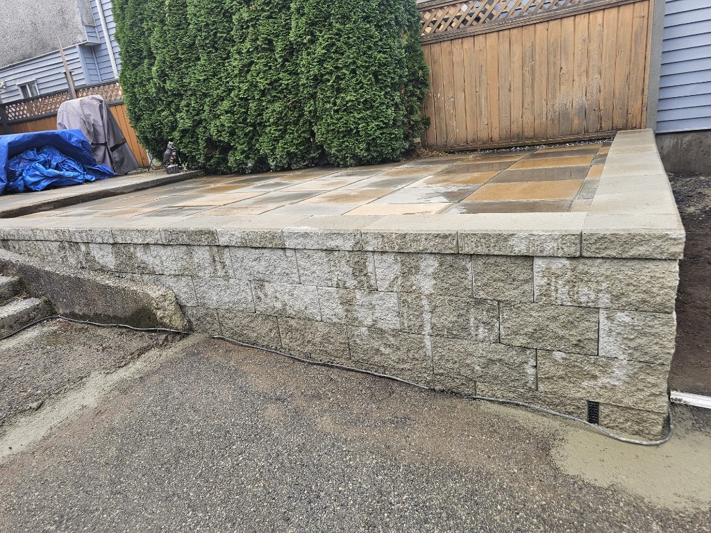 Finished concrete block retaining wall holding the rebuilt paver patio